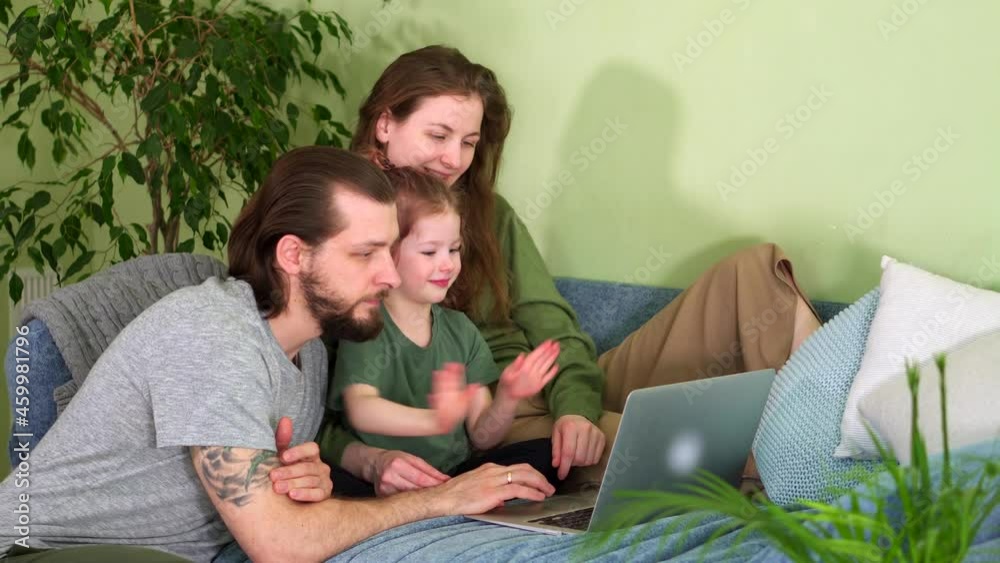 Happy family dance on sofa at home on couch look in laptop together laugh. Online conversation talking. Remote training via Internet. Work at home. Call your parents. Teach preschooler have fun. Crazy Happy family dance on sofa at home on couch look in laptop together laugh. Online conversation talking. Remote training via Internet. Work at home. Call your parents. Teach preschooler have fun. Crazy