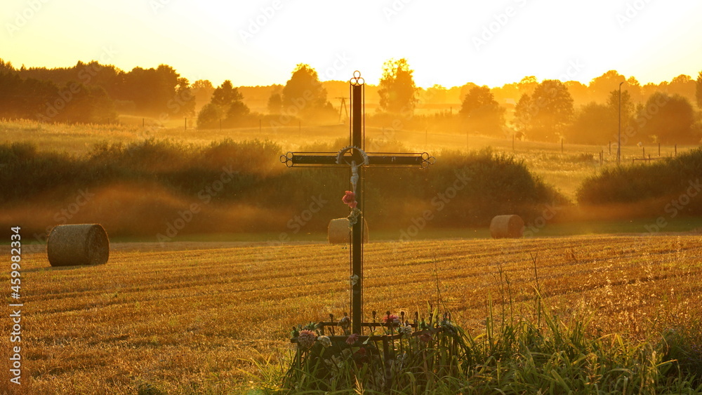 Kapliczka z krzyżem niedaleko pola na wsi - obrazy, fototapety, plakaty 