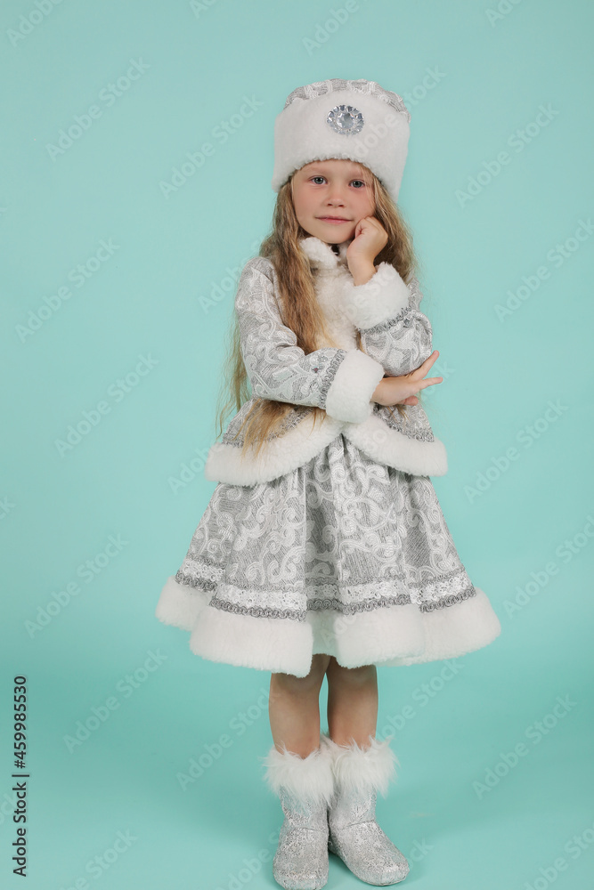 Obraz premium beautiful blonde girl with blue eyes with long hair in a snow maiden costume on a blue background new year