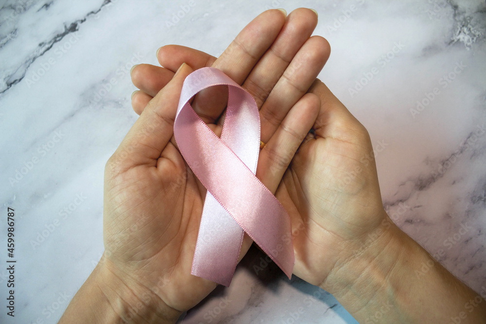 Pink October. Hands holding pink ribbon on pink background. Pink October. Hands holding pink ribbon on pink background.