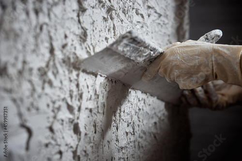 Plastering the wall. Hand holding a spatula with construction mix .Internal construction and finishing works