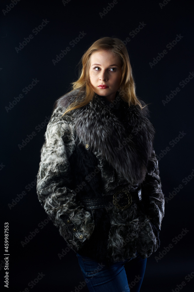 Young attractive woman in fur coat over black Young attractive woman in fur coat over black
