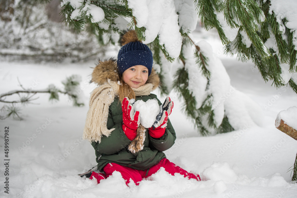 Happy child girl plaing with snow on a snowy winter walk Happy child girl plaing with snow on a snowy winter walk