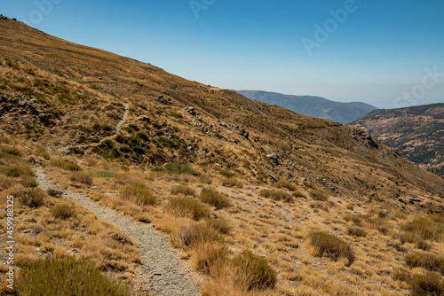 Scenic landscape with a hiking trail in the beautiful Poqueira Valley underneath Mount Mulhac  n  leading to Capileira village  Las Alpujarras  Sierra Nevada National Park  Andalusia  Spain