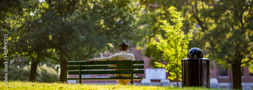 Man in a hat sitting on a park bench  alone