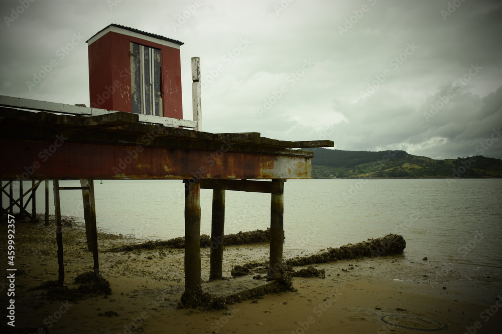 A shack built on a precarious pier out over the seaside