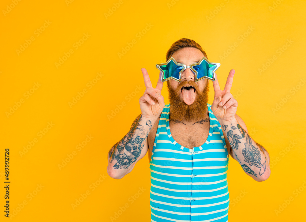 man with beard,tattoos and swimsuit is ready for the summer