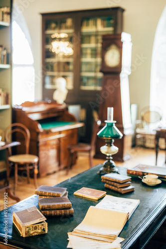 interior of an old house cabinet with books, wooden furniture and lamp