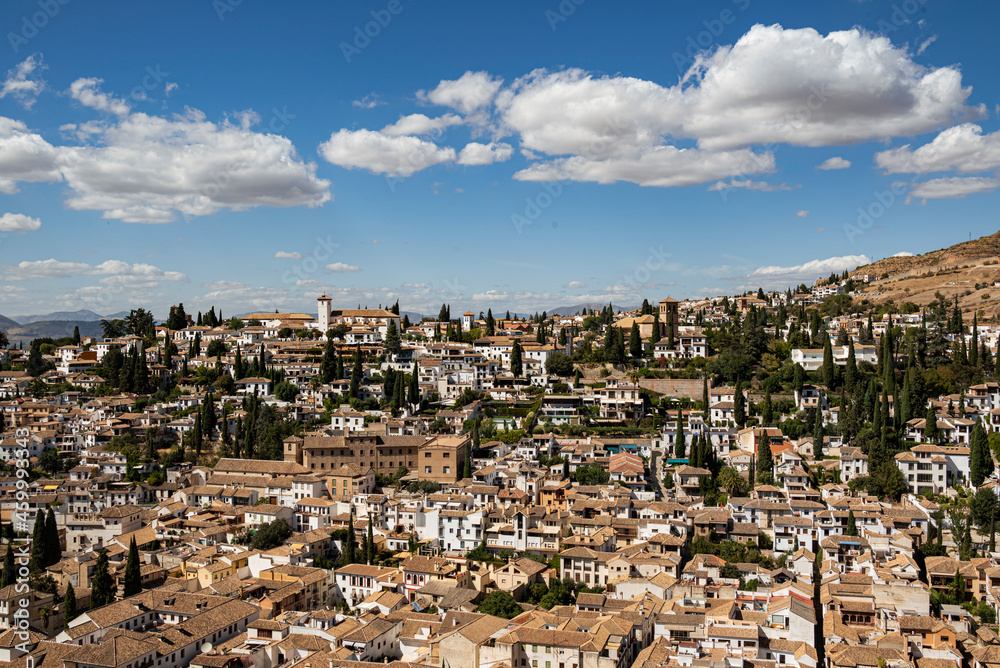 Beautiful panorama of the Albaicín, the historic city center of Granada with its characteristic white house under a picturesque  sky, seen from the Alhambra palace, Andalusia, Spain
