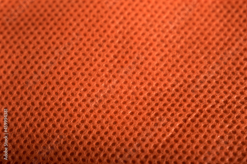 Texture of an orange reusable bag as background on a black table
