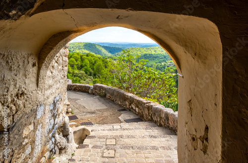 Photography A covered walkway leads to an road along the edge of the walled medieval village of Tourrettes-Sur-Loup in the Alpes-Maritimes area of Southern France