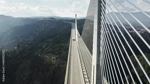 Vehicles driving on modern Vila Real Bridge, Portugal, Europe. Aerial shot of passing cars on road bridge over Corgo river in mountains. Autos moving on road of vehicle building, 4k footage photo