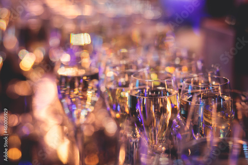 Line of alcohol setting on catering banquet table, bartender pouring beverages, row of different colored alcohol cocktails on a party, martini, vodka, and others on decorated banquet table event