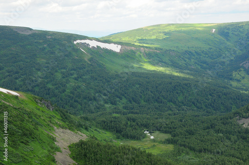 A view of the taiga high in the mountains  with small lakes and remnants of snow.
