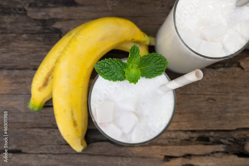 Banana fresh cocktail vanilla smoothies fruit juice beverage healthy the taste yummy in glass drink episode good morning on wooden background from the top view.