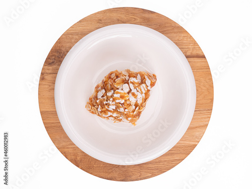 top angle of fresh croissant covered almond slide and topping with sugar powder on a white plate placed on circle vintage wood. food concept on photography image with clipping path included.