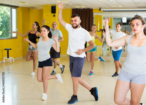 Women and men are dancing boogie-woogie in pairs in modern studio.