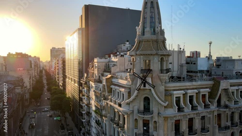 Cinematic aerial pan shot capturing heritage building Confiteria del Molino located at the junction between avenida rivadavia and callao avenue with big bright sun setting in the background. photo
