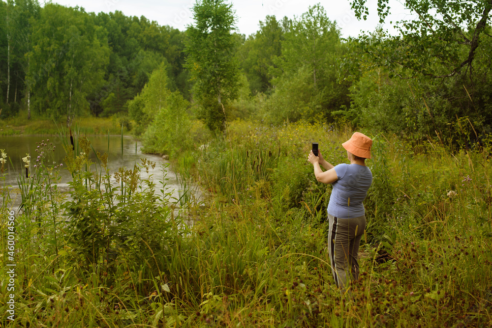 woman with smartphone by the river. communication away from civilization. woman with smartphone by the river. communication away from civilization.