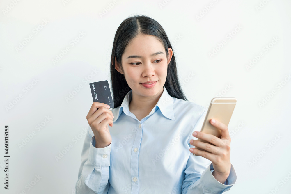 The Asian businesswoman's hand is holding a credit card and using a smartphone for online shopping and internet payment in the office The Asian businesswoman's hand is holding a credit card and using a smartphone for online shopping and internet payment in the office