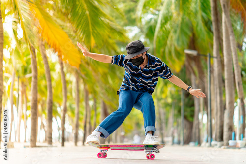 A young Asian man in a striped shirt and trousers is figure skating on a beach filled with coconut palms, during a clear sky time. and no people beach , surf skating, Bangsaen, Thailand