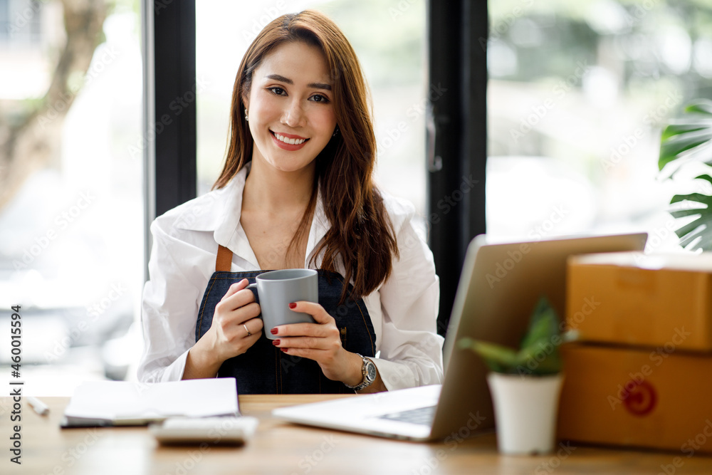 Portrait of Asian young woman SME working with a box at home the workplace.start-up small business owner, small business entrepreneur SME or freelance business online and delivery concept. Portrait of Asian young woman SME working with a box at home the workplace.start-up small business owner, small business entrepreneur SME or freelance business online and delivery concept.