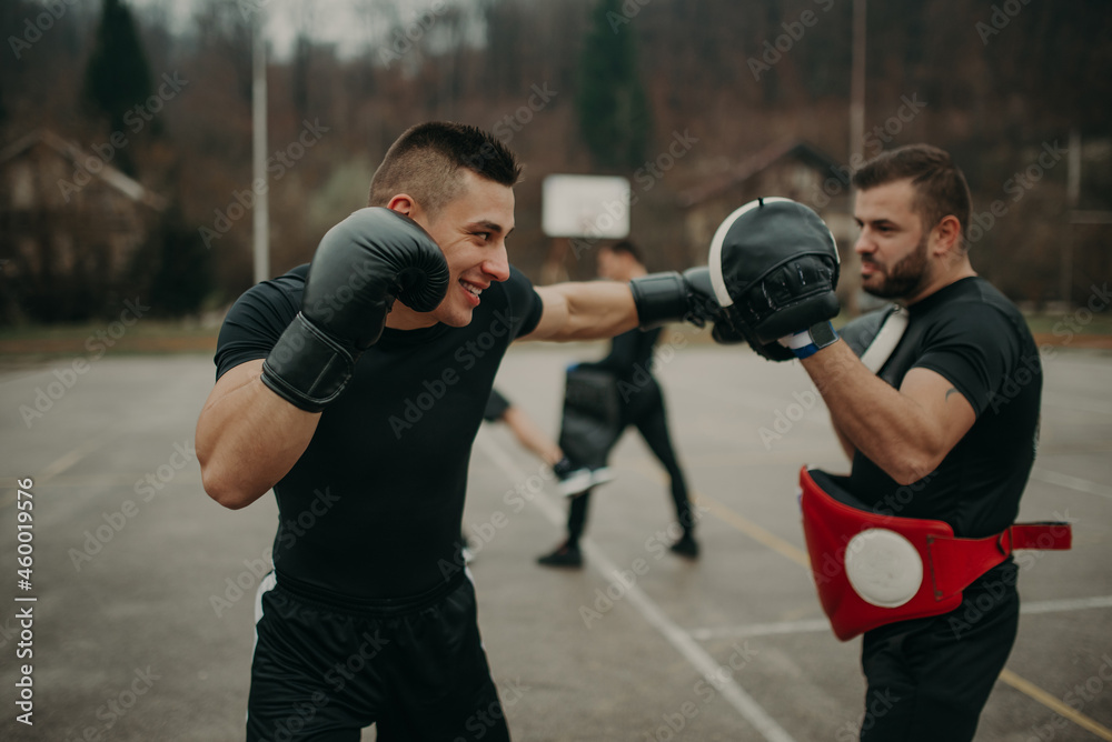 Man training kick box with his professional trainer Man training kick box with his professional trainer