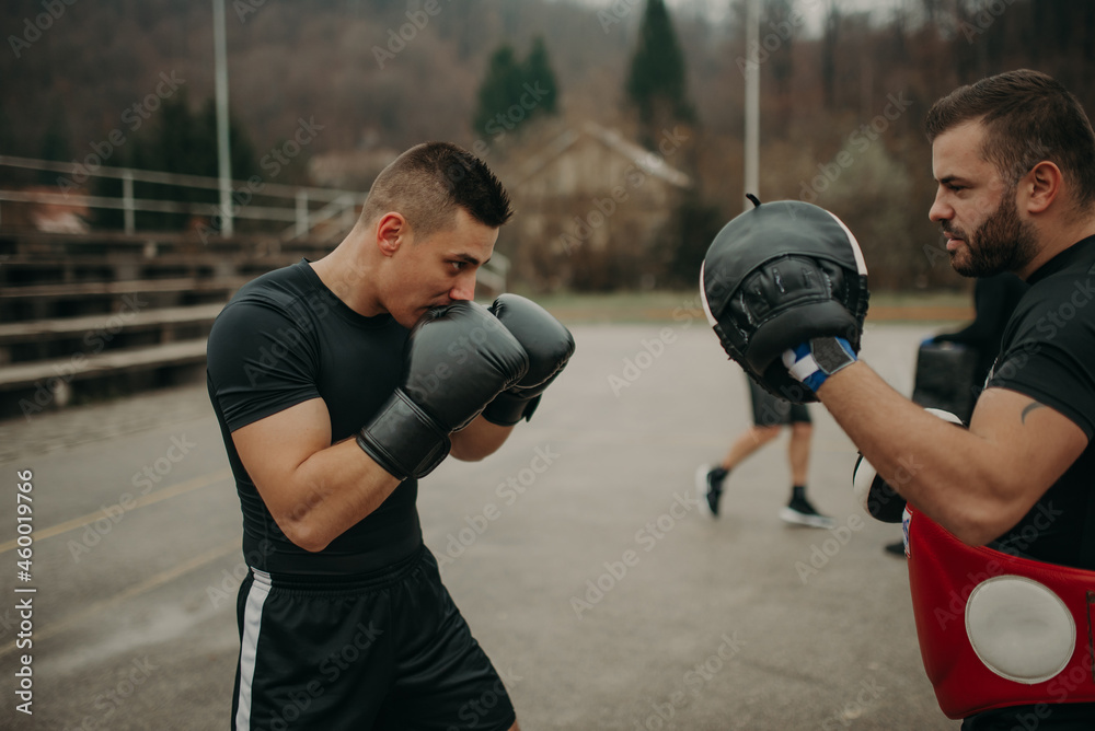 Man training kick box with his professional trainer