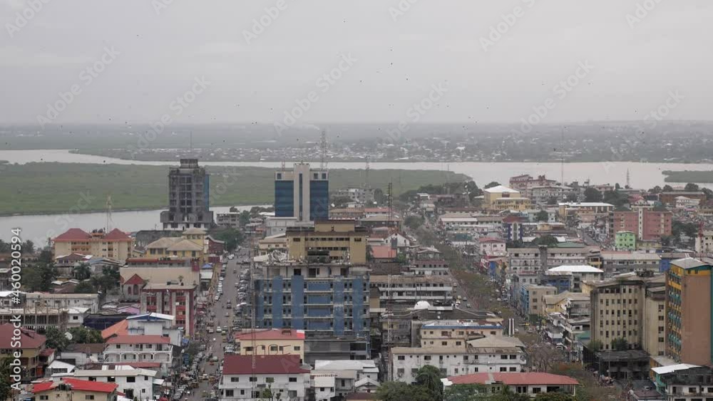 Still shot of skyline of Monrovia, Liberia on a cloudy day with bats flying overhead Still shot of skyline of Monrovia, Liberia on a cloudy day with bats flying overhead