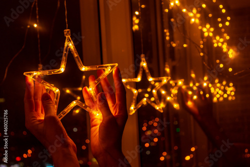 Stars in the window . Christmas decoration with garland lights and stars at winter seasonal holidays