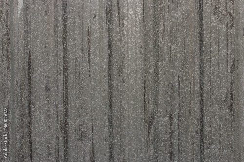 Gray corrugated metal or zinc textured surface or galvanized steel against a vertical line or texture background. Background.