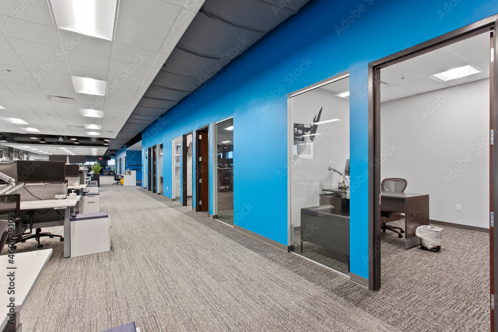 Light and spacious coworking office with white tables and walls, wooden