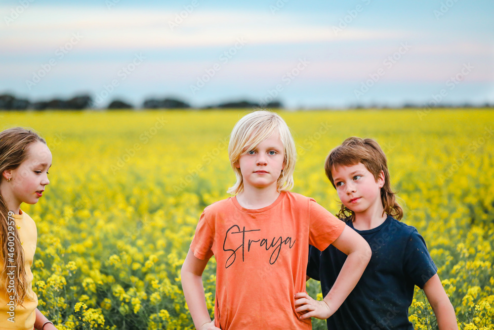 Two Aussie boys posing together in front of canola field with 'Straya' text on shirt, Australian slang term Two Aussie boys posing together in front of canola field with 'Straya' text on shirt, Australian slang term