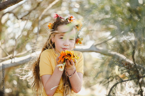 Portrait of pretty girl with vibrant orange and yellow wildflowers