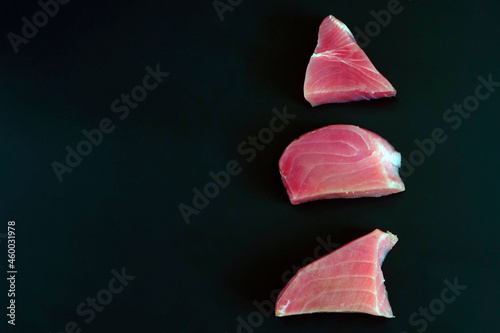 Raw tuna steak on a black background. The concept of a healthy diet  a source of protein  ingredients for cooking  useful trace elements  vitamins and omega. copy space.