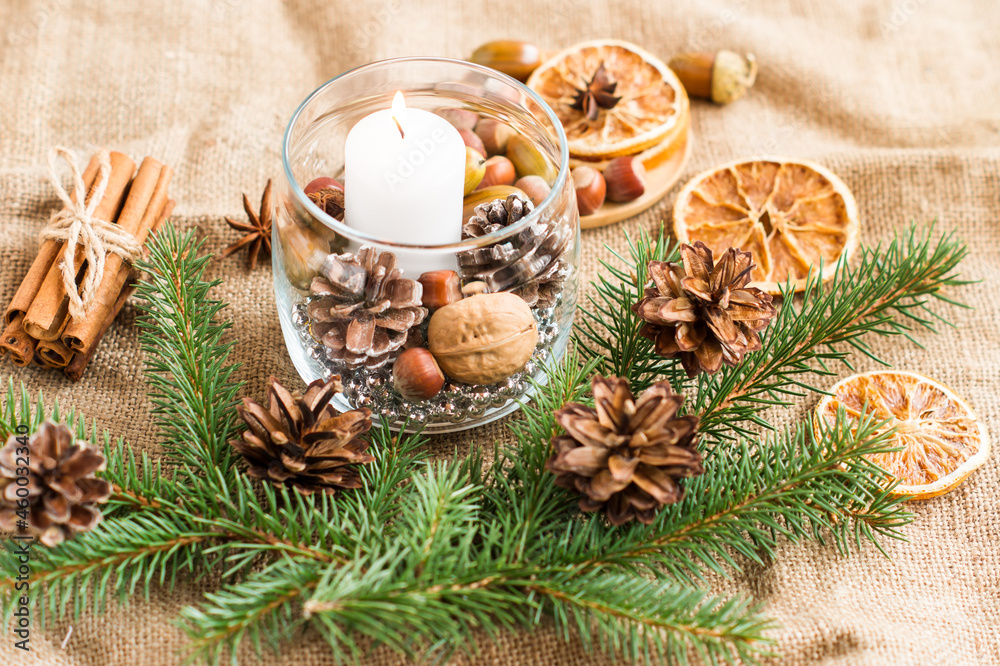 new-year composition of a burning white candle in a glass jar with natural ingredients and branches of spruce. the concept of New Year's decor. new-year composition of a burning white candle in a glass jar with natural ingredients and branches of spruce. the concept of New Year's decor.