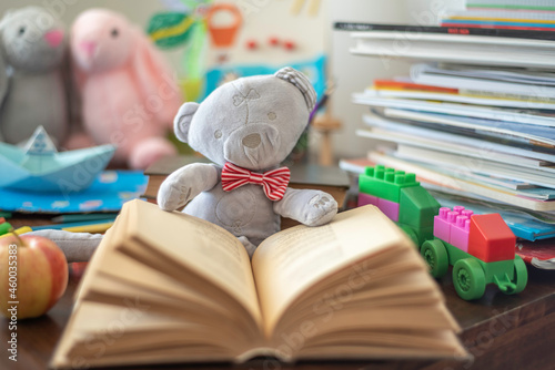 Education background. Plush bear on book and toy background. Back to school concept.
