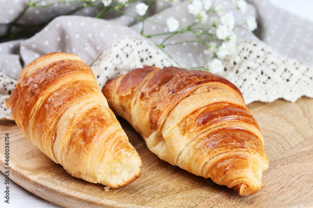 French croissants made of puff pastry on a wooden table.