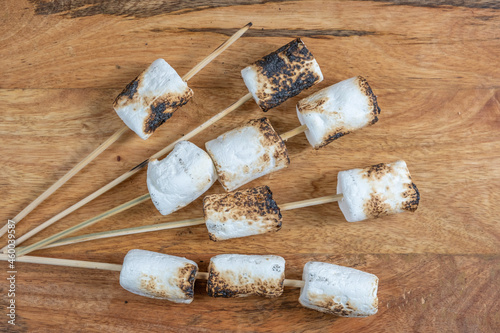 Grilled marshmallows on wooden background. photo