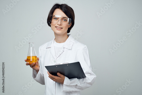 female laboratory assistant in a white coat test tube with a chemical solution analysis