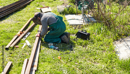 Welding works. A man welder with construction gloves and a welding mask working with a metal outdoors © supersomik