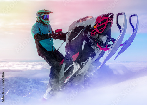 a snowmobiler rides and jumps in the snowy mountains. prof pilot of a mountain snowmobile in bright gear without brands for travel advertising