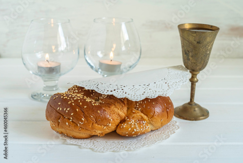 Challah bread for Shabbat on white wooden background.