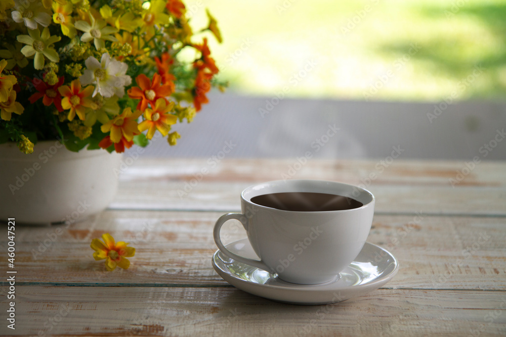   White cup of coffee on wood table on nature background,