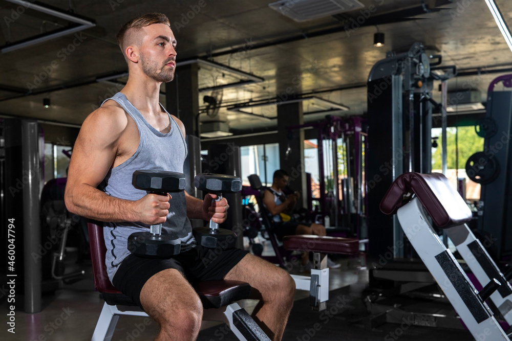 Handsome Athletic Men Exercising with dumbbells modern gym. Fitness men with naked torso doing workout . Handsome Athletic Men Exercising with dumbbells modern gym. Fitness men with naked torso doing workout .