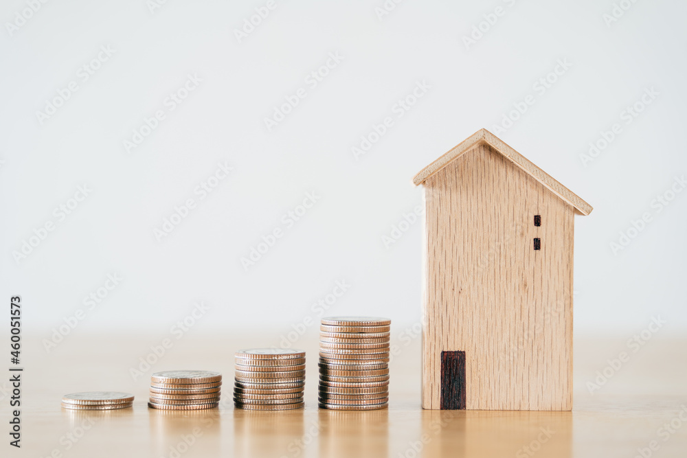 Wooden house and stacking coins on wooden table. saving money for buying house, financial plan home loan concept. Wooden house and stacking coins on wooden table. saving money for buying house, financial plan home loan concept.