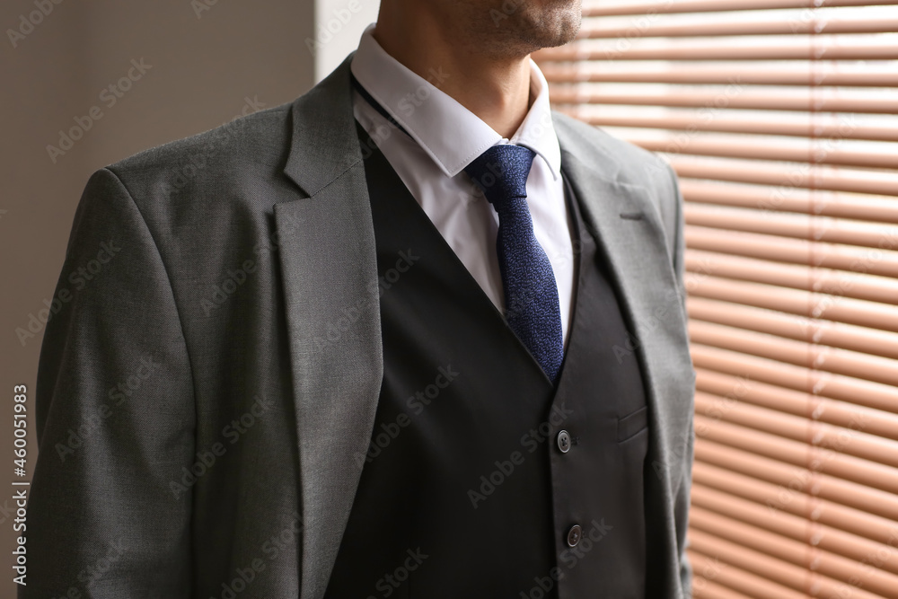 Young man in stylish suit near window Young man in stylish suit near window