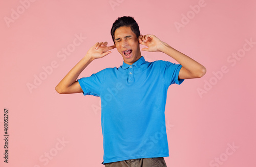 Portrait of young teen boy, student wearing blue shirt posing isolated on pink studio backgroud. Human emotions concept. photo