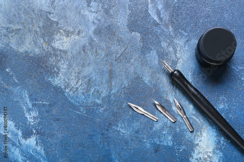 Nib pen with ink on blue ba...