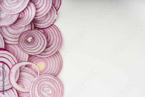 Sliced red onion rings on white table background